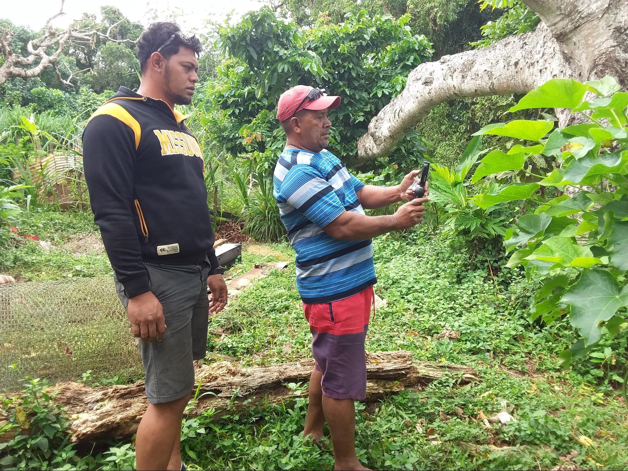 推广干事 Tangaki Aloua 和 Selimoti Fetokai 在地块调查前寻找香草种植园的确切位置